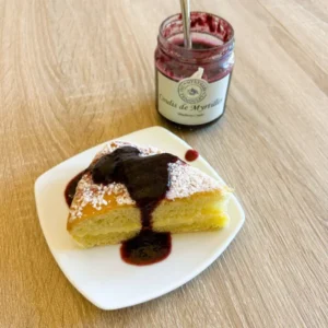 Coulis de myrtilles artisanal nappant un gâteau maison, texture onctueuse parfaite pour sublimer vos desserts