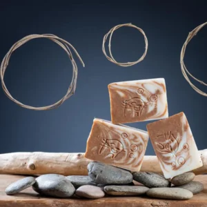 Trois pains de savon cannelle avocat artisanal Savonnerie des Monédières sur galets et bois flotté, marbrage tourbillonnant brun et crème saponifié à froid