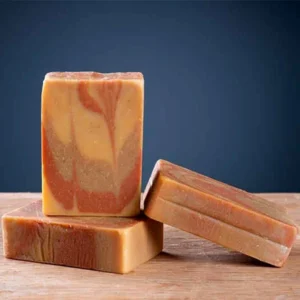 Trois pains de savon miel amande douce artisanal de la Savonnerie des Monédières, marbrage beige et orangé avec argile rouge, format 100g