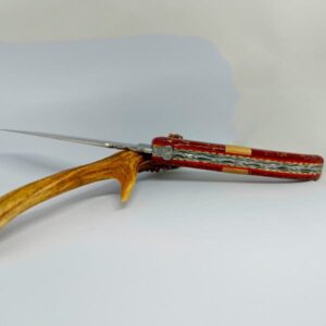 Un couteau Laguiole "De Feux et d'Or" de 12 cm, fabriqué par Laguiole Laffont, avec un manche riche orné de jaspe d'or et encadré de mitres en mimosa. Le design intègre des platines en inox et laiton pour une solidité exceptionnelle, et une lame en acier 14C27 qui promet une coupe précise et durable. Le ressort, méticuleusement forgé et guilloché, témoigne de l'expertise et du soin apportés à chaque détail.