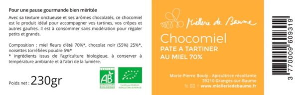 L'image montre l'étiquette de design plat d'un pot de pâte à tartiner "Chocomiel" de la marque "Miellerie du Baume". La moitié gauche de l'étiquette est de couleur crème et contient un texte descriptif qui dit : "Pour une pause gourmande bien méritée. Avec sa texture onctueuse et ses arômes chocolatés, ce chocomiel est le produit idéal pour accompagner vos tartines, vos crêpes et autres gaufres. Il est à consommer sans modération pour régaler petits et grands." La composition est listée comme "miel fleurs d'été 70%, chocolat noir (55%) 25%, noisettes torréfiées poudre 5%*" avec une note que les ingrédients proviennent de l'agriculture biologique. Les instructions indiquent de conserver à température ambiante et à l'abri de la lumière. Le poids net est de "230gr" et le logo AB (Agriculture Biologique) est visible. La moitié droite de l'étiquette est orange avec le nom du produit "Chocomiel PATE A TARTINER AU MIEL 70%" écrit verticalement en blanc, et le logo de la marque en haut. Le nom de l'apicultrice "Marie-Pierre Bouly - Apicultrice récoltante - 39210 Granges-sur-Baume" est en bas, suivi par l'URL "www.mielleriedubaume.fr". Sur la droite, se trouve un code-barres.