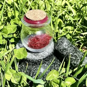 Pot en verre de pur safran bio en stigmates 0,5 g cultivé en Corrèze, épice artisanale française, flacon scellé avec bouchon en liège et cire, posé sur mortier.